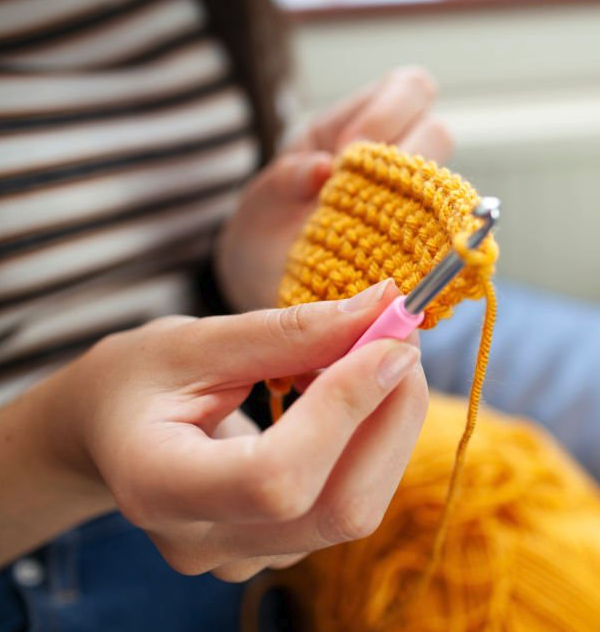 Hand holding a crochet hook and yarn